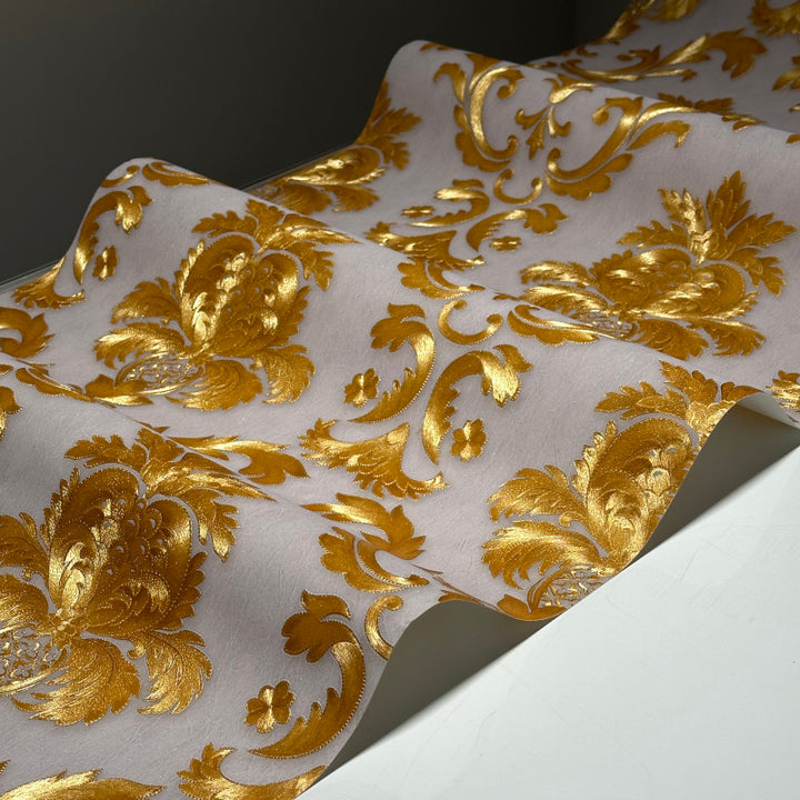 Close-up of gold embossed damask wallpaper with metallic texture for bedroom walls